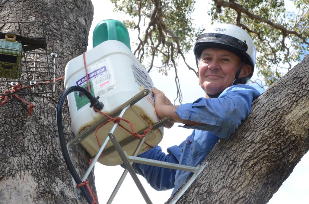 Local farmer Robert Frend refills one of the Blinky Drinkers being used to research the drinking habits of koalas in Gunnedah.