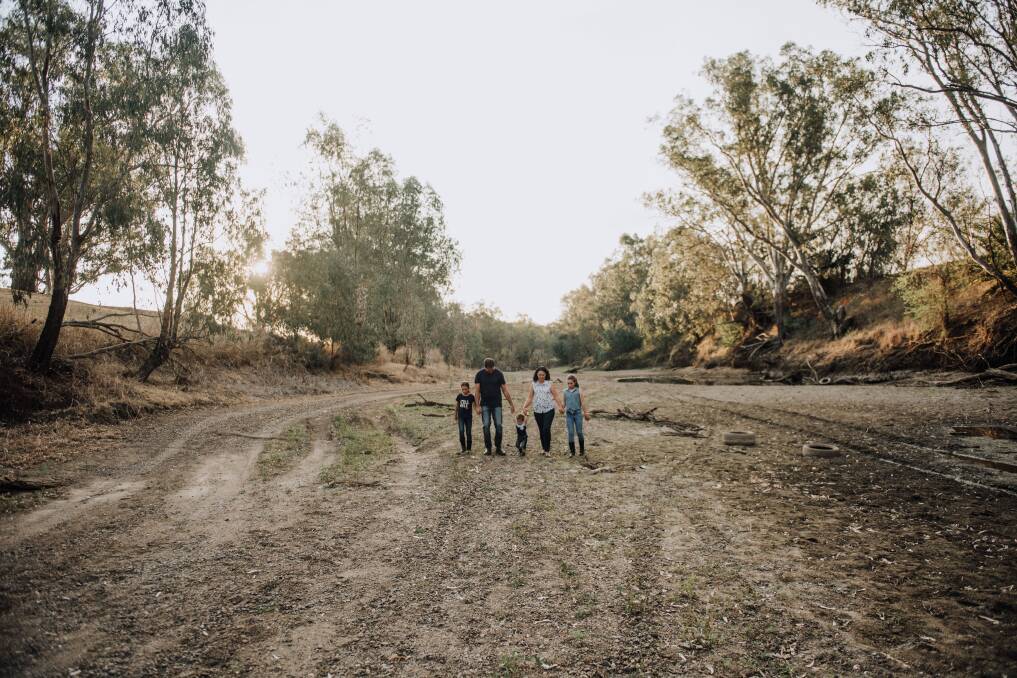 Liana Burwood, Thomas, Matthew and Helen Rosenzweig, and Zenae Burwood walking up the middle of the bone-dry Namoi River in Gunnedah last week. Photo: Finishing Image Photography