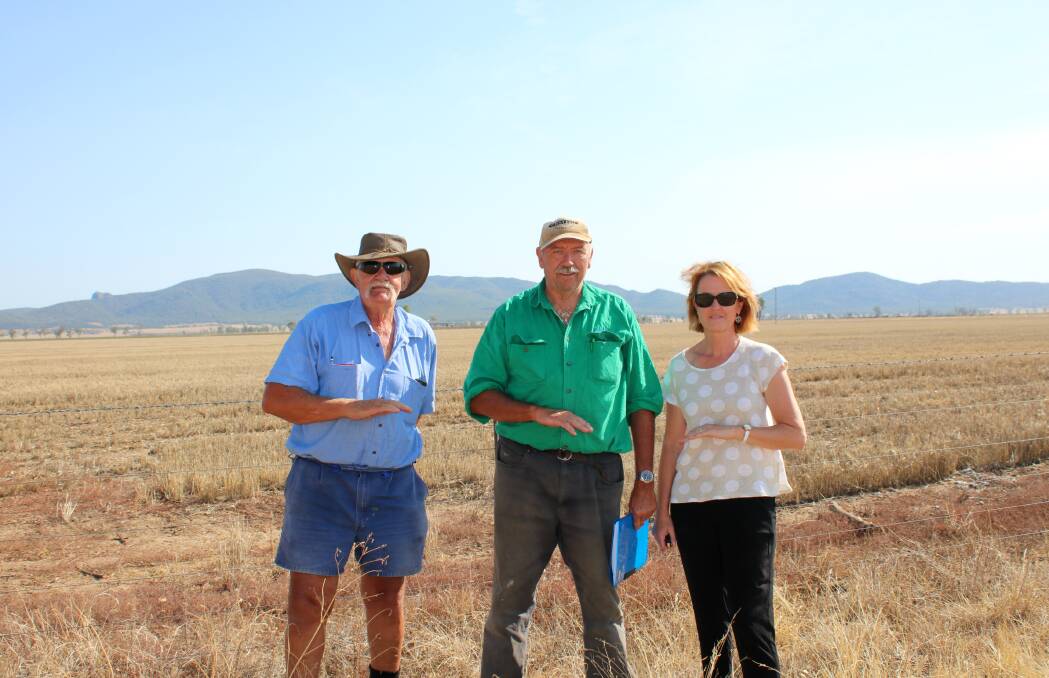 Malcolm Payne (left) says not enough has been done to address potential flood impacts. He is pictured here with neighbours Phil Glover and Leah Woods in 2018, indicating the height that flood water can reach on Orange Grove Road.