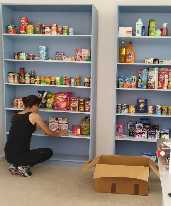 Jodie Baldwin stocking shelves in the food pantry in the old CWA rooms in Premer. Photo: supplied