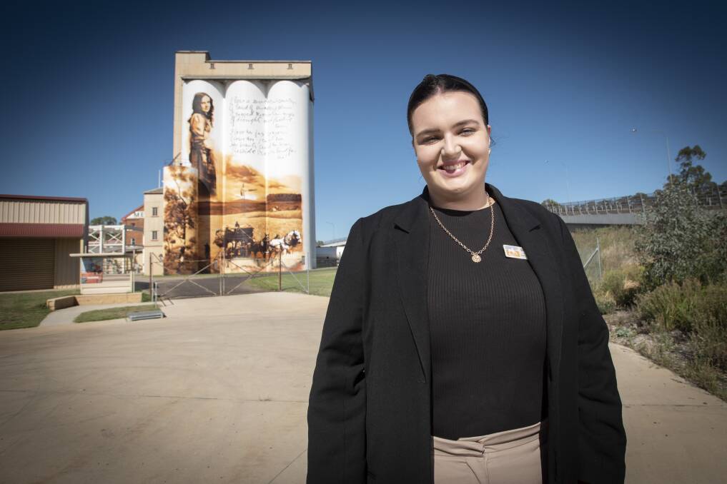 Poetry awards officer Brittany Riley with the iconic art mural featuring the late Dorothea Mackellar. Photo: Peter Hardin