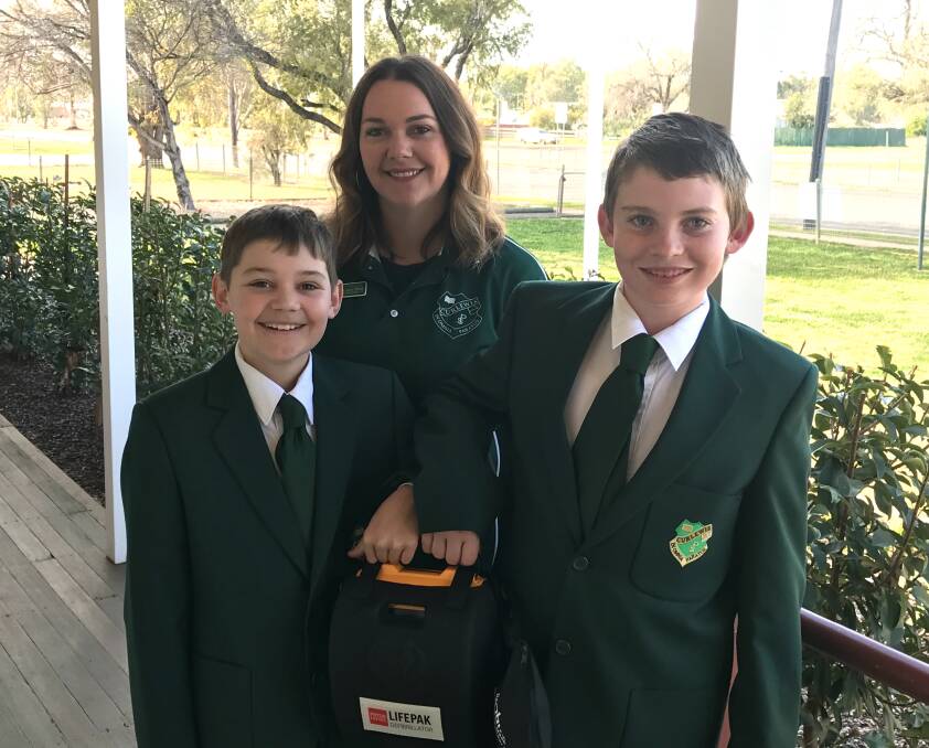 Curlewis Public School now has a defibrillator thanks to the community. Pictured are school captains Logan West and Peter McCormack, and P&C president Casey West. Photo: Peter Baum