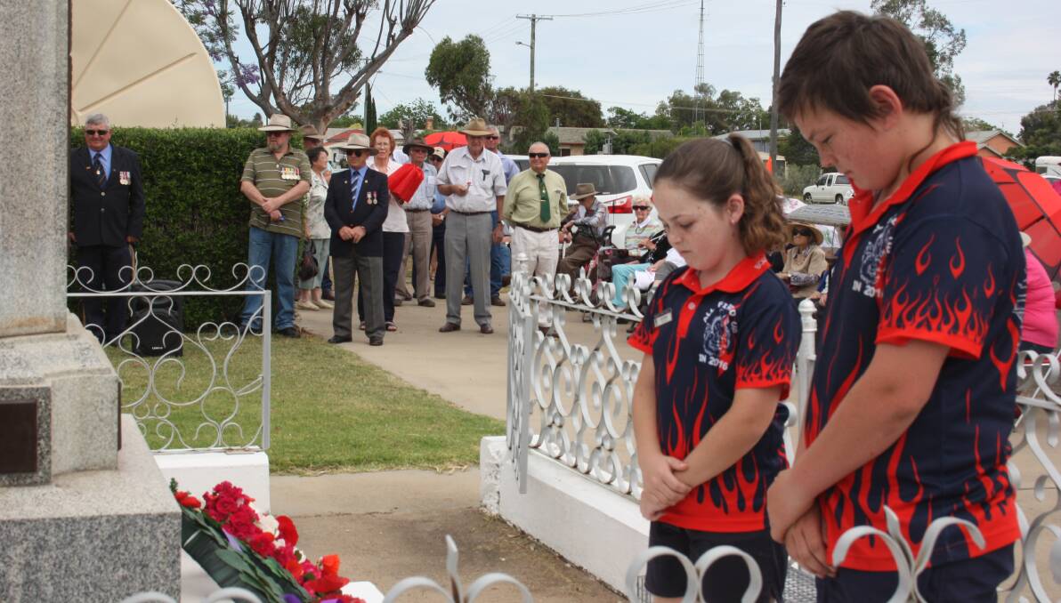 Boggabri Public School students Jorja Kemp and Daniel McMillan pay their respects after placing a wreath at the cenotaph on Remembrance Day.