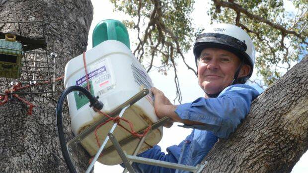 Gunnedah farmer Robert Frend refills a Blinky Drinker he designed to helps keep koalas hyrdrated. Photo: Marie Low