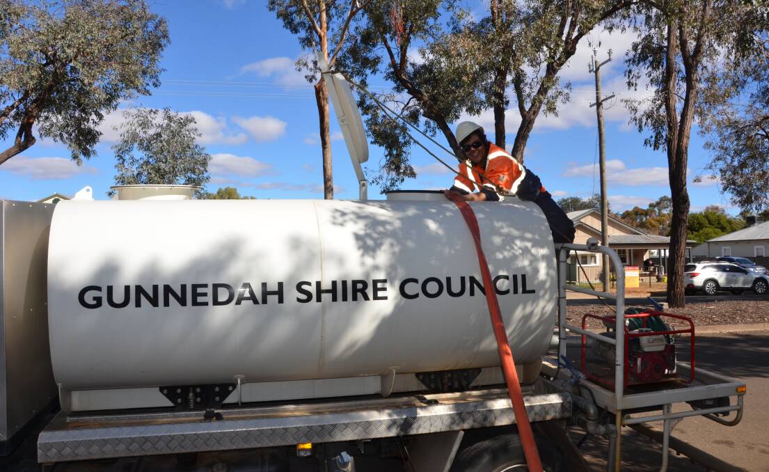 PITCHING IN: Gunnedah Shire Council employee Kyle Ball helps top up a water truck from the Gunnedah pool. Photo: Billy Jupp 