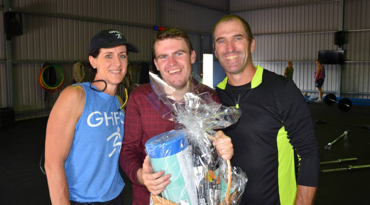 HELPING HAND: Gunnedah Health and Fitness Co's Maryanne Perkins presents Brandon and Mick Edmunds with a running gift basket. Photo: Billy Jupp 