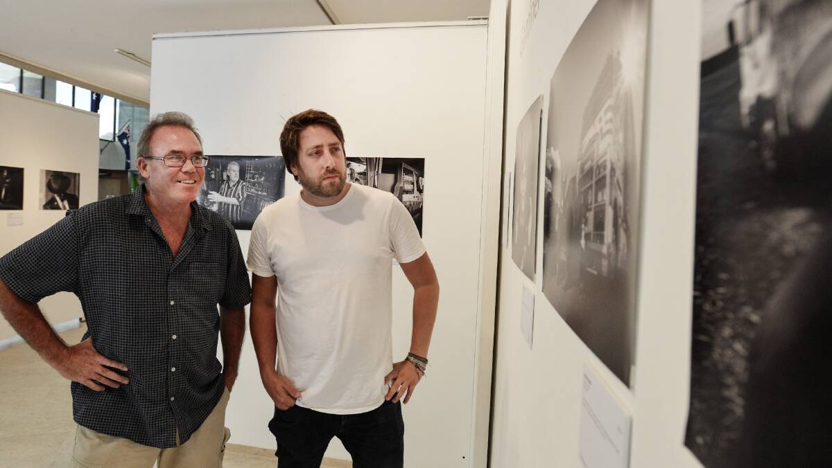 TO THE WALL: Peter Hardin and Gareth Gardner check out the display of their works in Ray Walsh House. 060219GGC01
