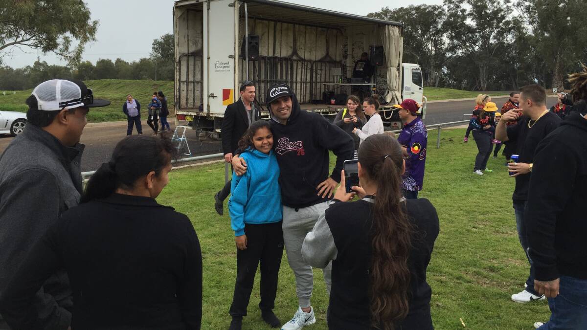 Anthony Mundine poses for a photo with a fan in Gunnedah on Wednesday.