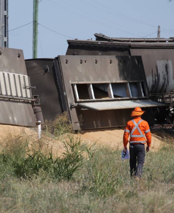 Wrecked: A worker inspects the scene of the grain train derailment at Emerald Hill where about four carriages came off the rails on Monday. Police did not report any injuries, however recovery was still under way on Tuesday morning.