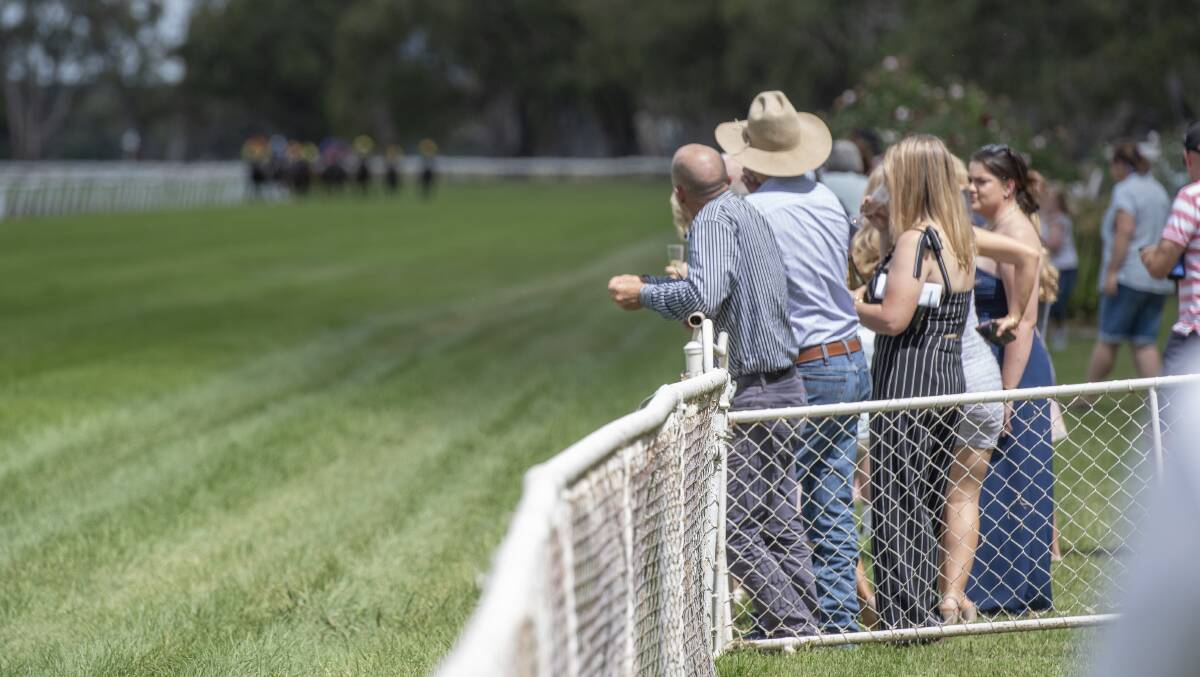 ON THE FENCE: Punters watch on at the Gunnedah Jockey Club on Boggabri Cup day. Photo: Peter Hardin