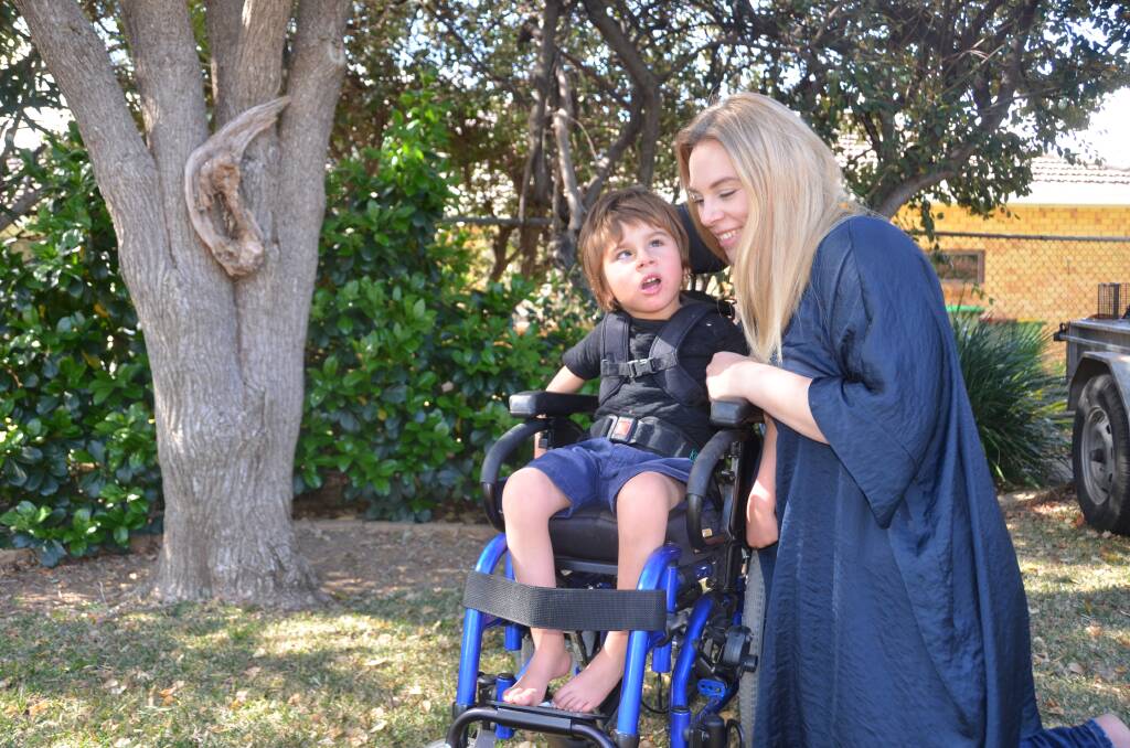 THANKFUL: Hugo and Rachael Young with his new $10,000 purpose-built wheelchair, which the Gunnedah community helped fundraise for. It arrived from the US three weeks ago. Photo: Ella Smith 