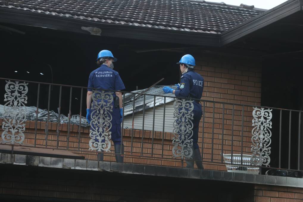 Police forensic officers check out the second floor of the house before venturing inside.