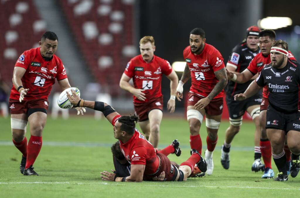 Keeping the play alive: Ben Gunter offloads to Masataka Mikami after a strong run during the Sunwolves' loss to the Lions in Singapore on Saturday. Photo: AP Photo/Danial Hakim