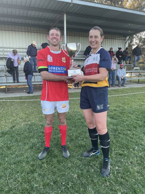 Gunnedah skipper James Perrett receives the Kookaburra Challenge Cup from referee, Dr Rachel Horton after they reclaimed it from Inverell.