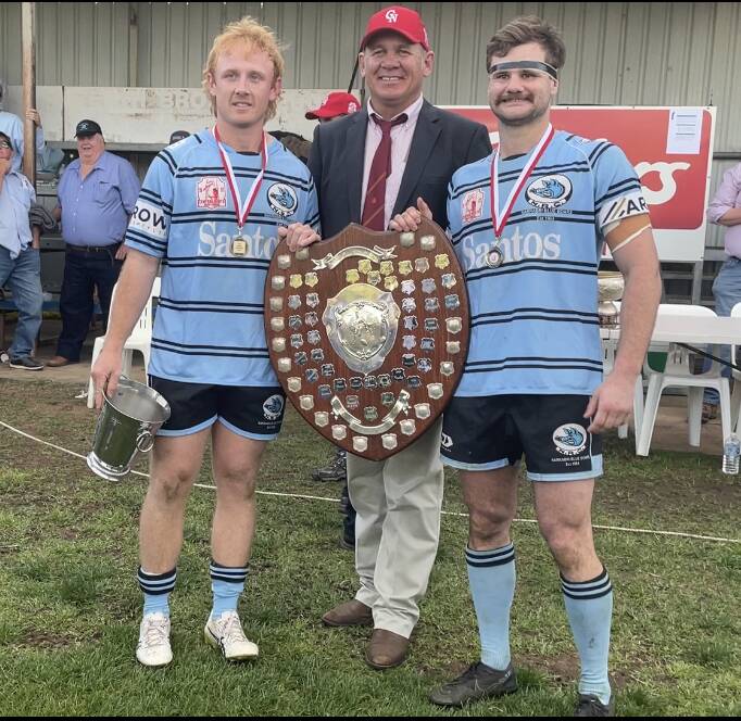 Narrabri co-captains Will McDonnell and Jacob Nichols accept the Heath Shield from Central North president Paul King.
