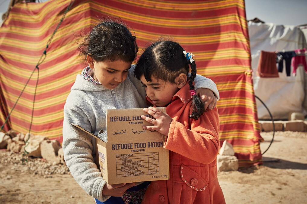 Refugees Esma and Mahida receive their ration pack. Photo: supplied