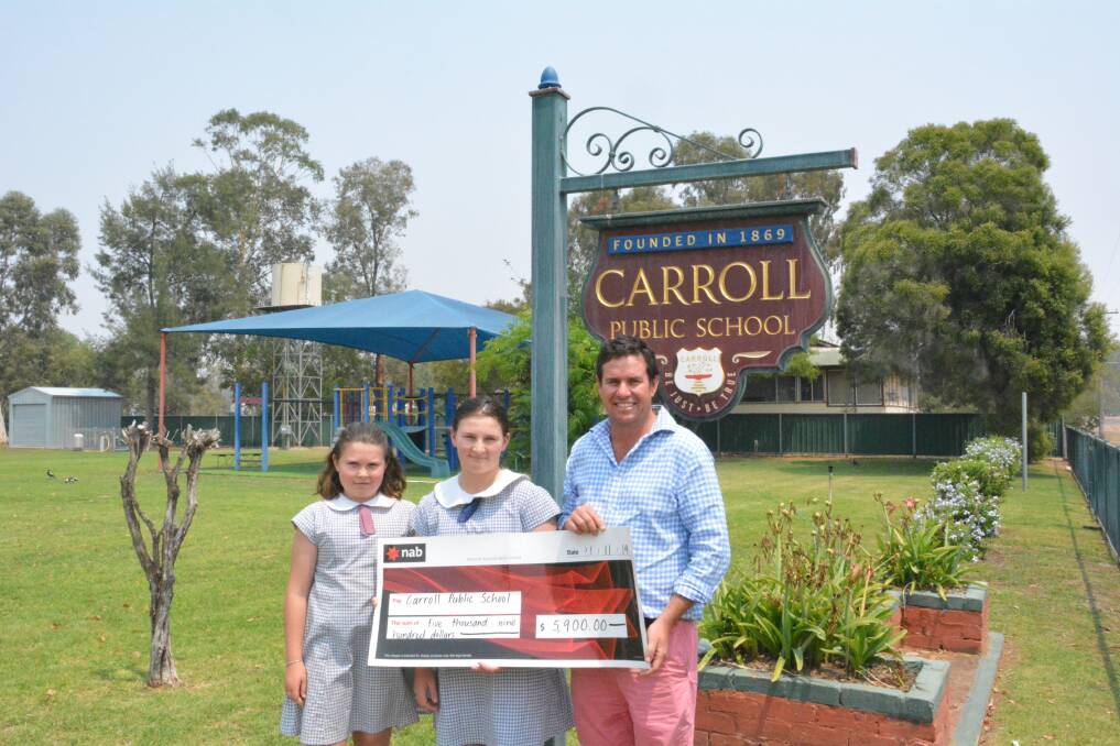 Carroll Public School captains Taleigha Elphick and Stephanie Faint accepting a cheque from Upper Namoi Cotton Growers Association chair Nick Beer. Photo: Jessica Worboys