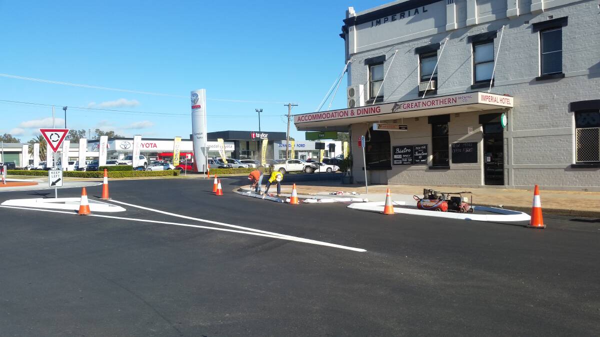 Workers put the final touches to new rubber kerbing at the Barber and Chandos streets roundabout. Photo: supplied
