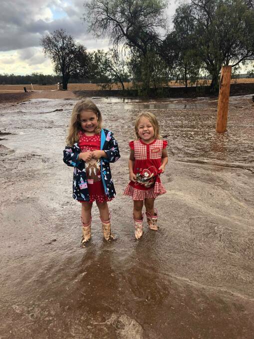 Six-year-old Darcie and three-year-old Bobbie are all smiles while playing in the big puddles on their property. Photo: Stacie Crane.