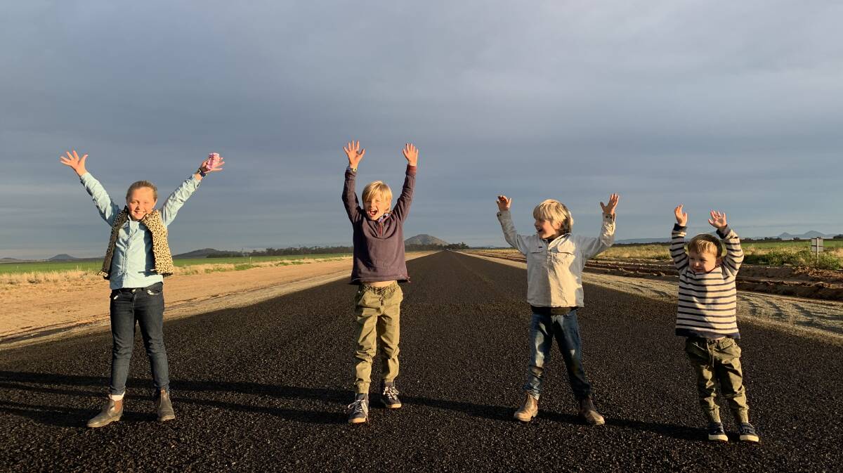 HIP HIP HOORAY: Susie, Tom, Ben and Harry Bell on Grain Valley Road after it was sealed at the start of their driveway. Photo: supplied
