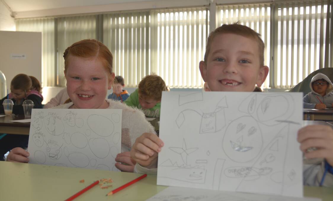 Eva Kelly and Jed McLoughlin at a cartooning workshop in 2019's July school holidays. More cartooning workshops will be held these school holidays. Photo: Jessica Worboys