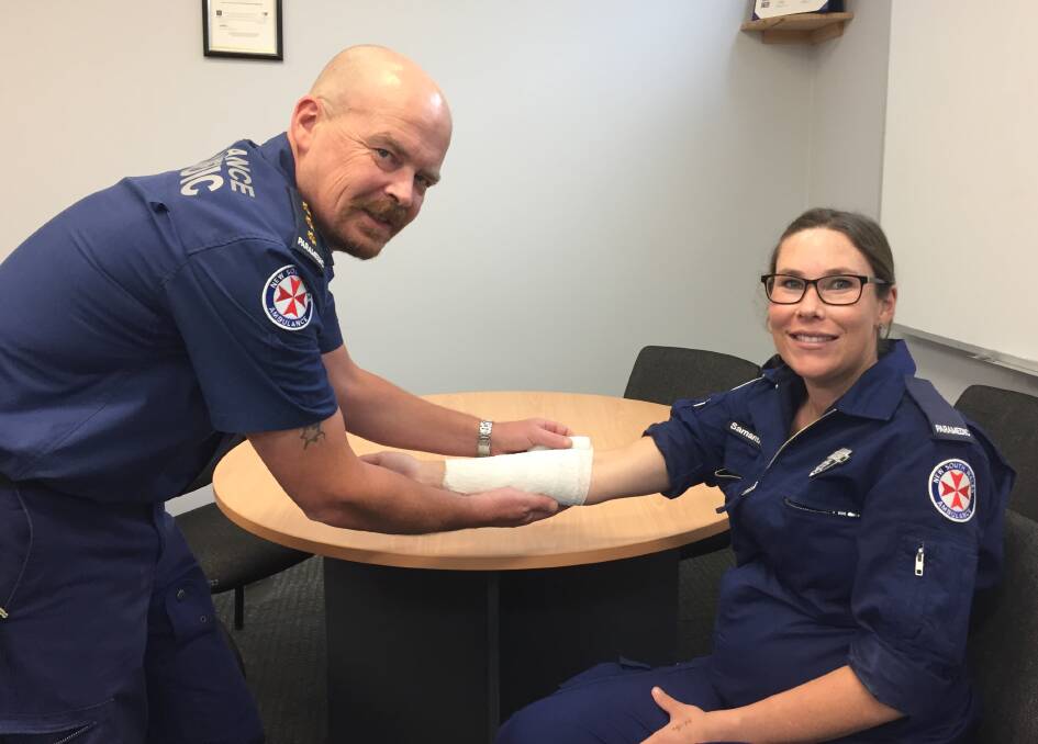 Correct approach: Inspector Chris Wilson from NSW Ambulance and paramedic Sam Baker demonstrate applying a bandage. Photo: Faye Wheeler