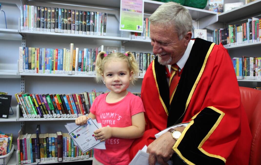 Darcie Crane is thrilled to receive a certificate for reading 750 books from Gunnedah mayor Owen Hasler.