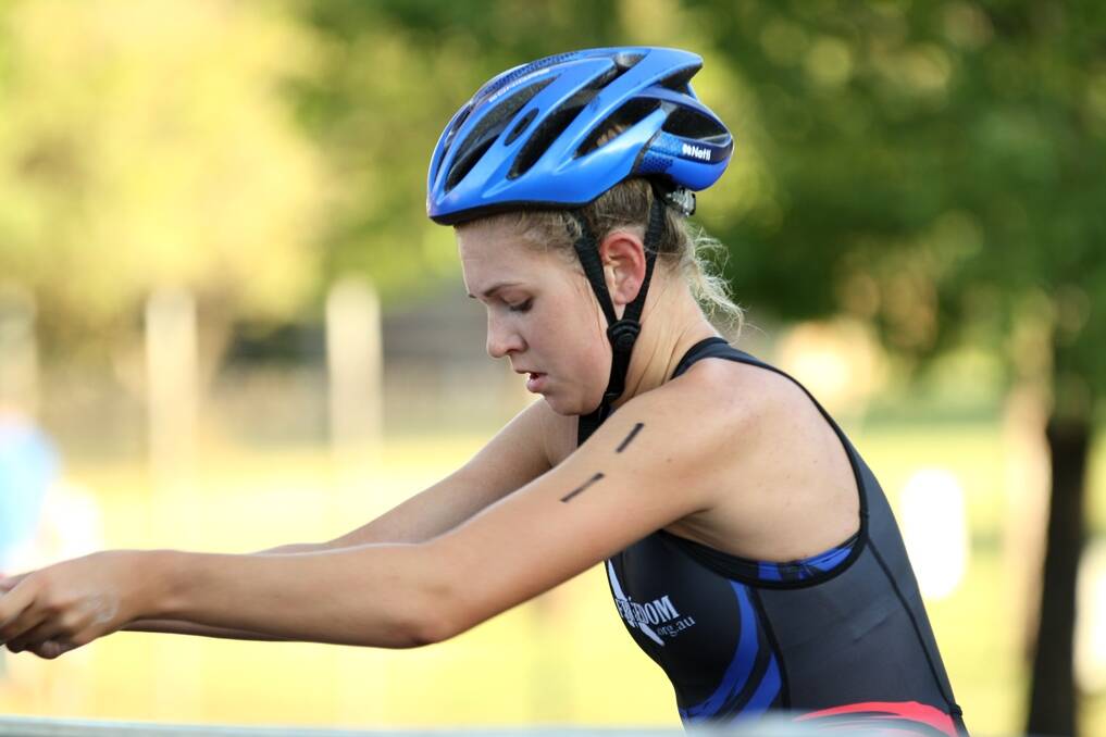Megan Isbester transitions from the bike leg to the run during Sunday's women's triathlon in Gunnedah.